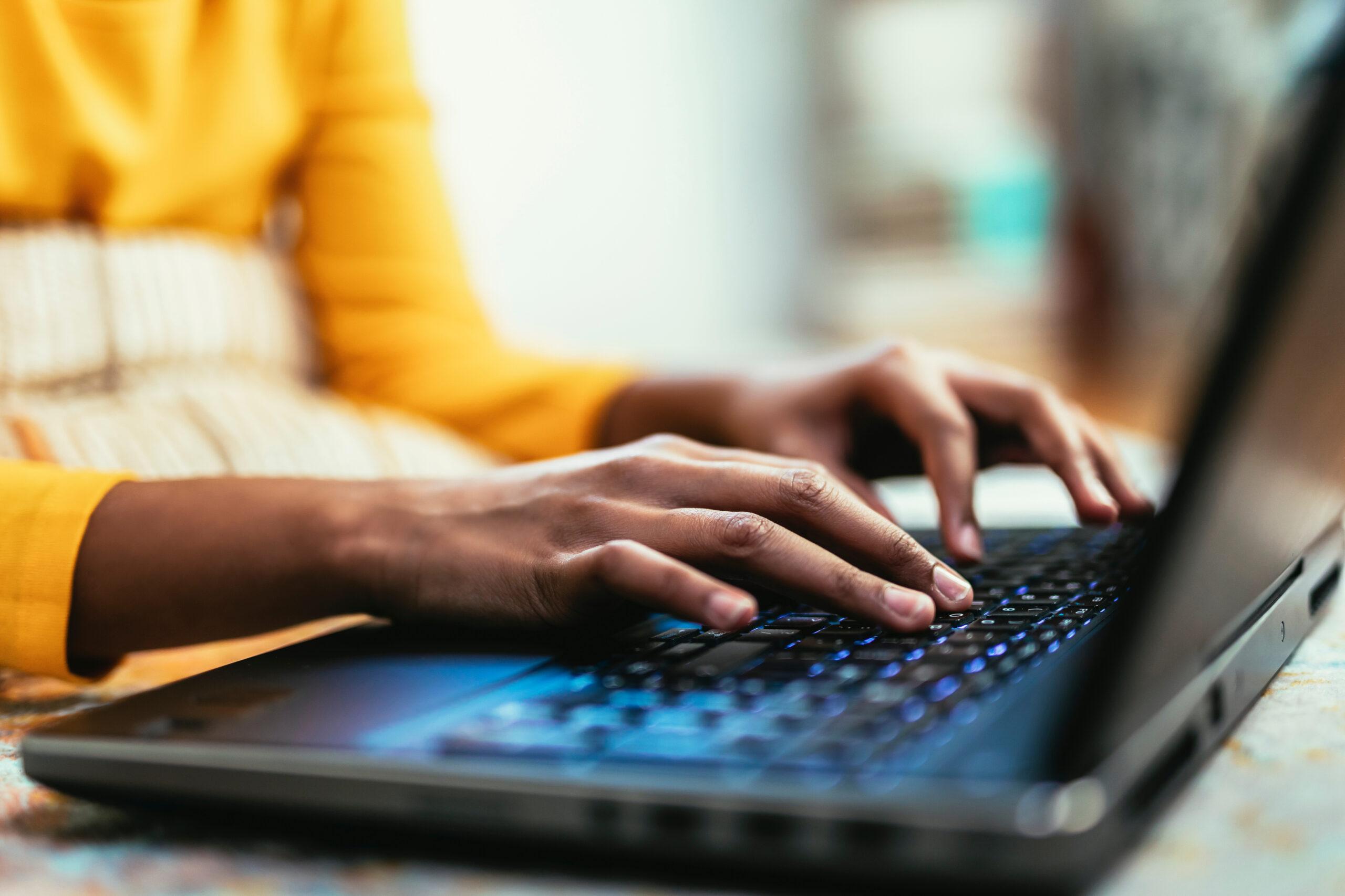 Close up hands typing using laptop computer. Woman browsing onli Hands typing at a laptop