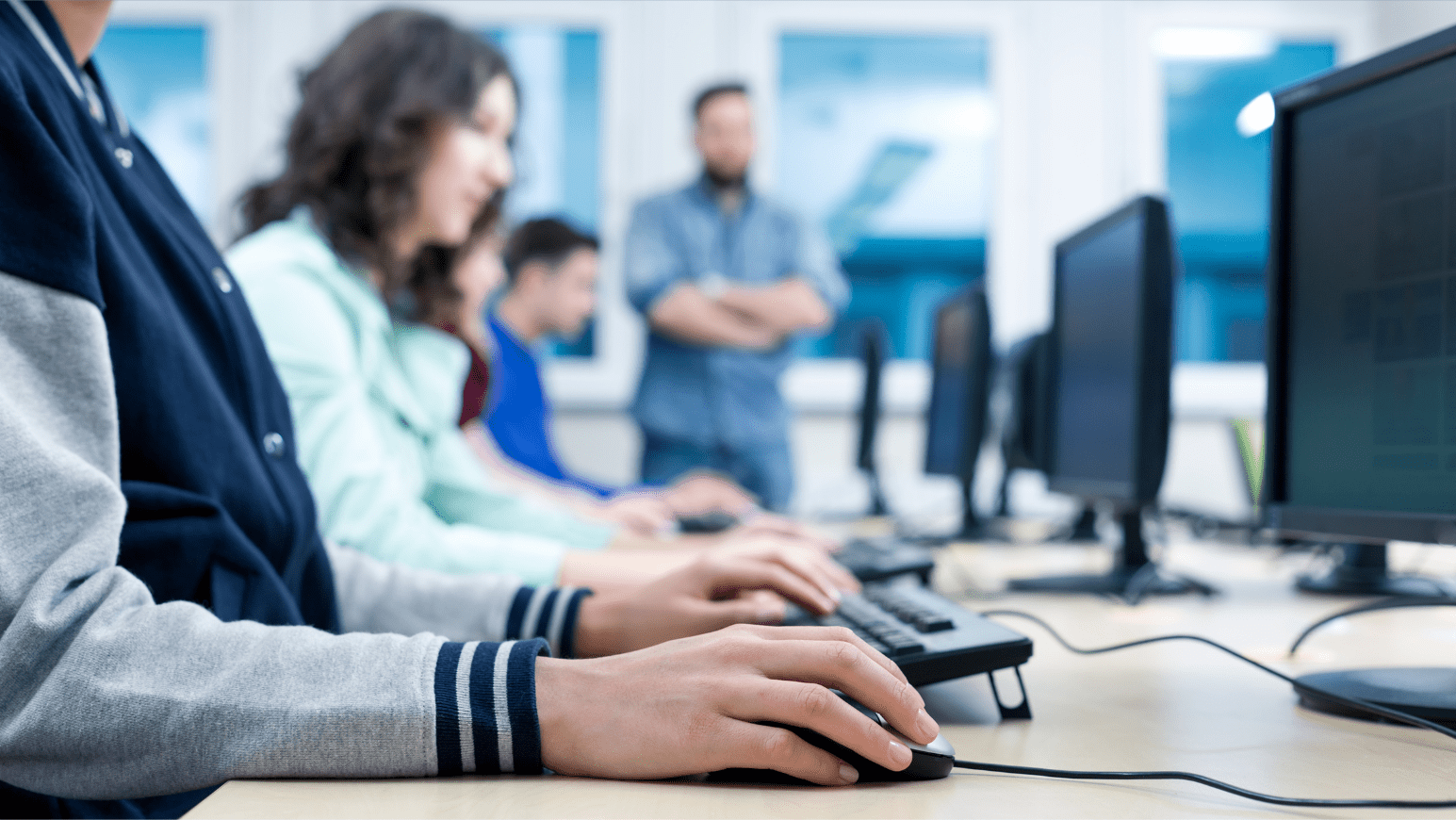People working at laptops in a classroom.