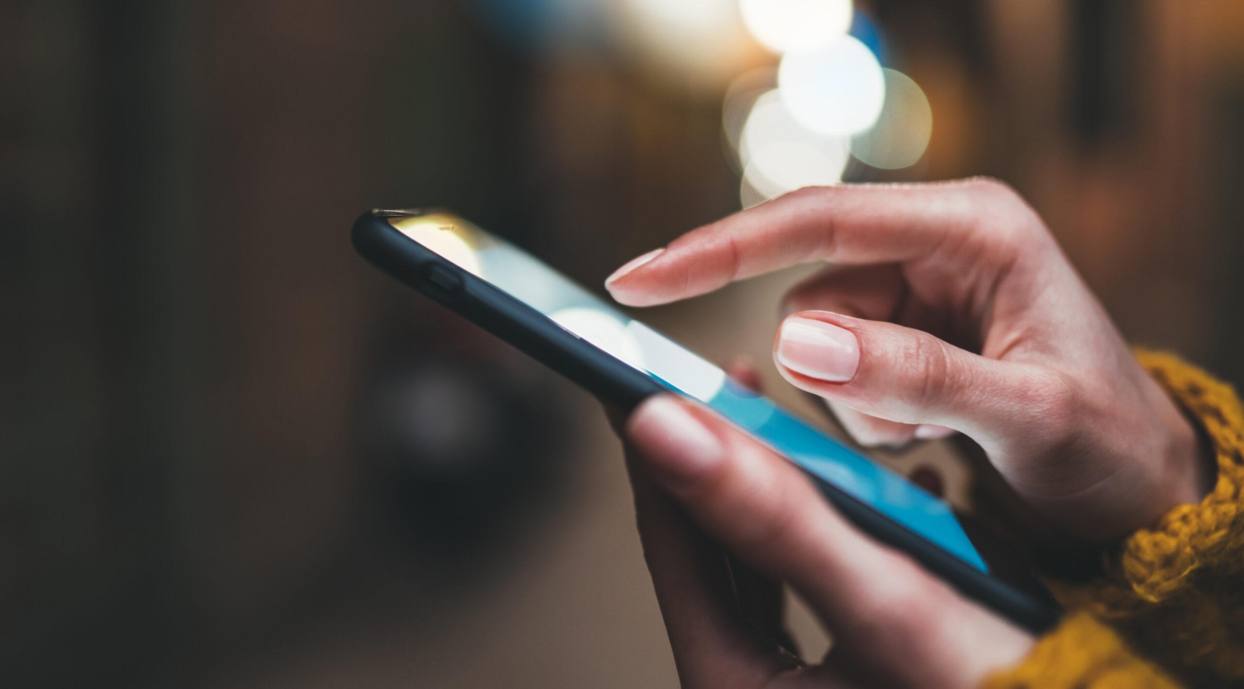point finger on screen phone closeup, person texting text messag A person's hand using a smartphone
