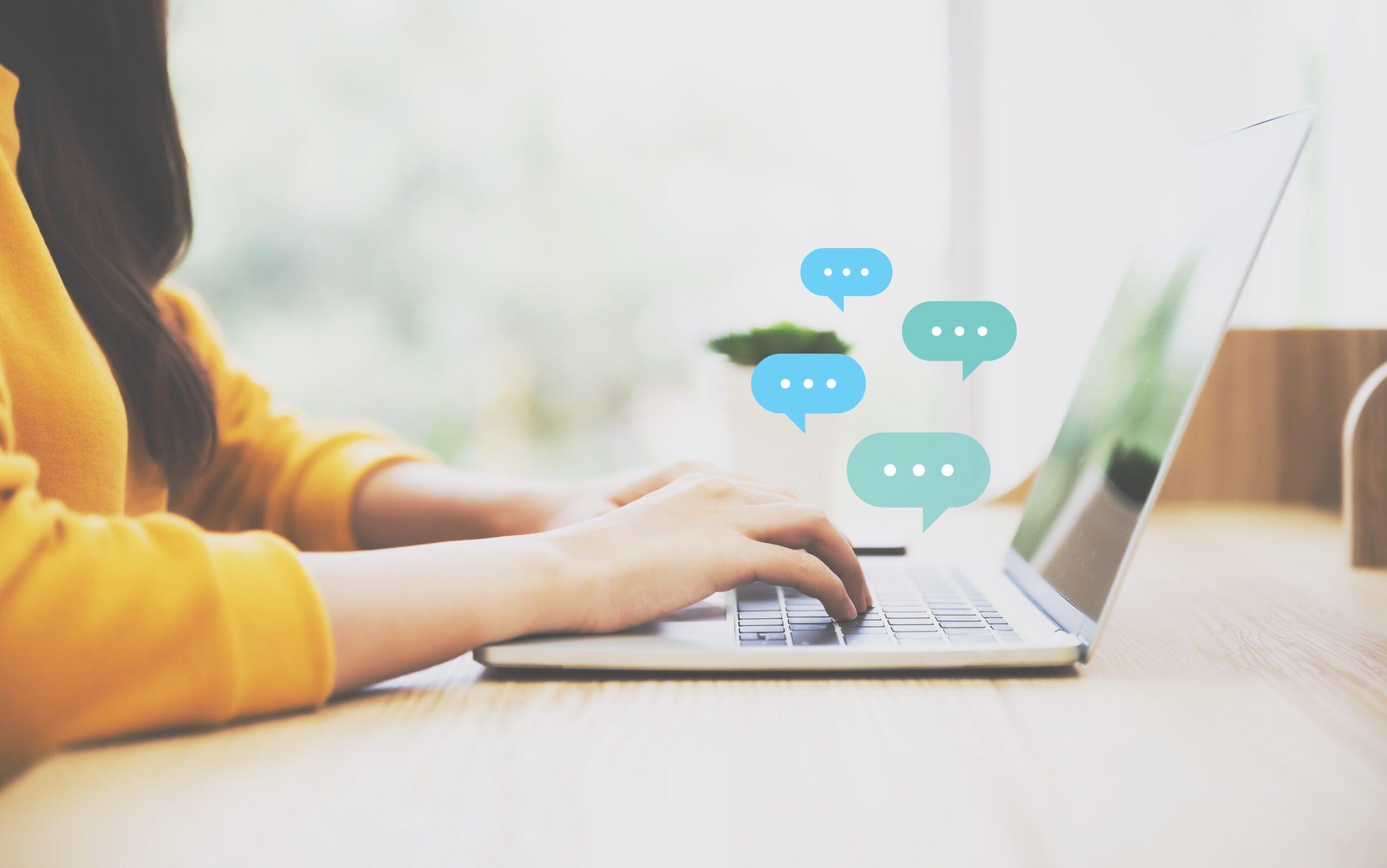 Stock photo of a person sending messages on a laptop.