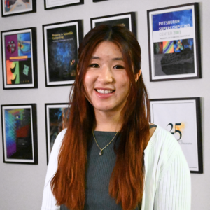 Portrait photo of a woman with light skin tone and brown-red hair.
