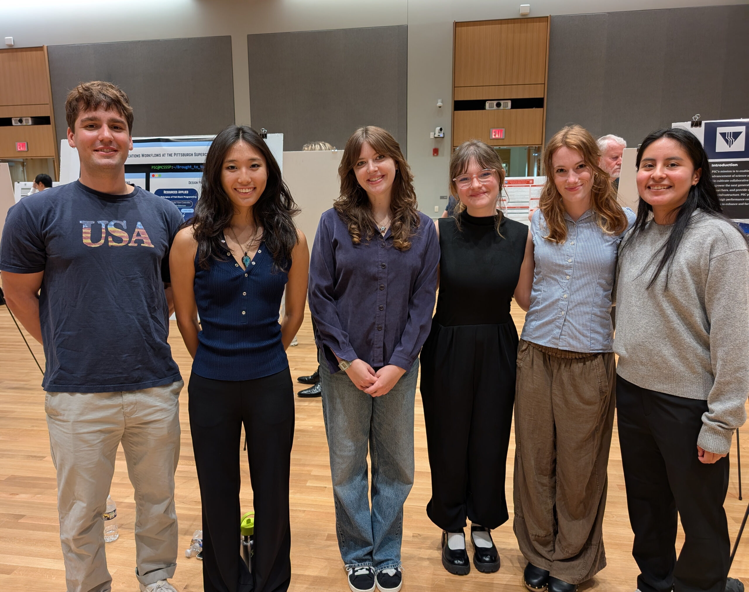 Group photo of six people at a poster session. 