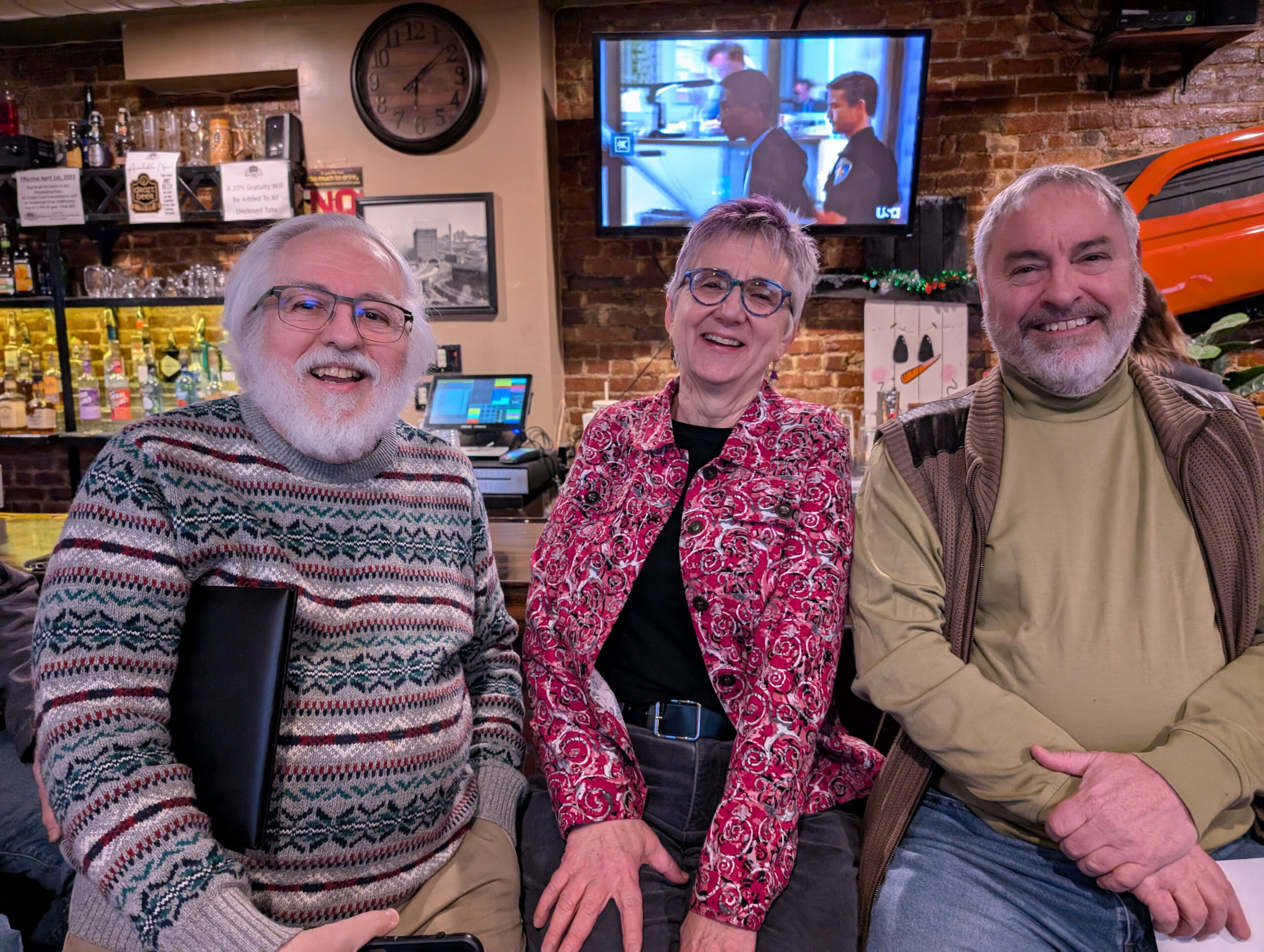 Three people smile for a photo