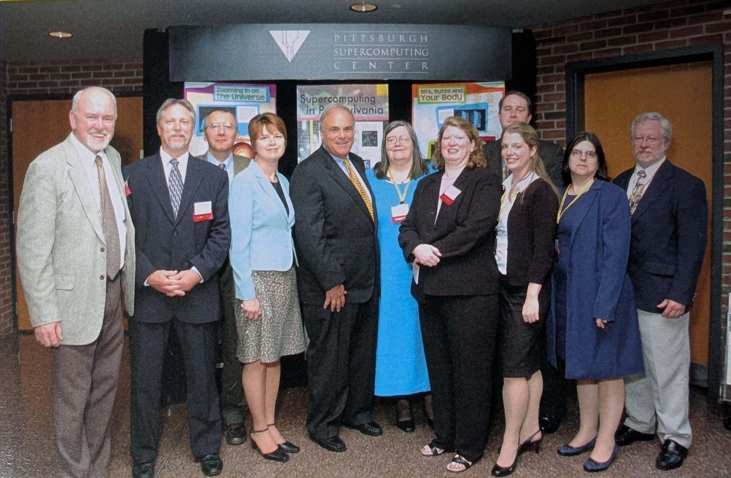 A group photo of 11 people in front of the PSC logo. Among them is Robin Scibek.