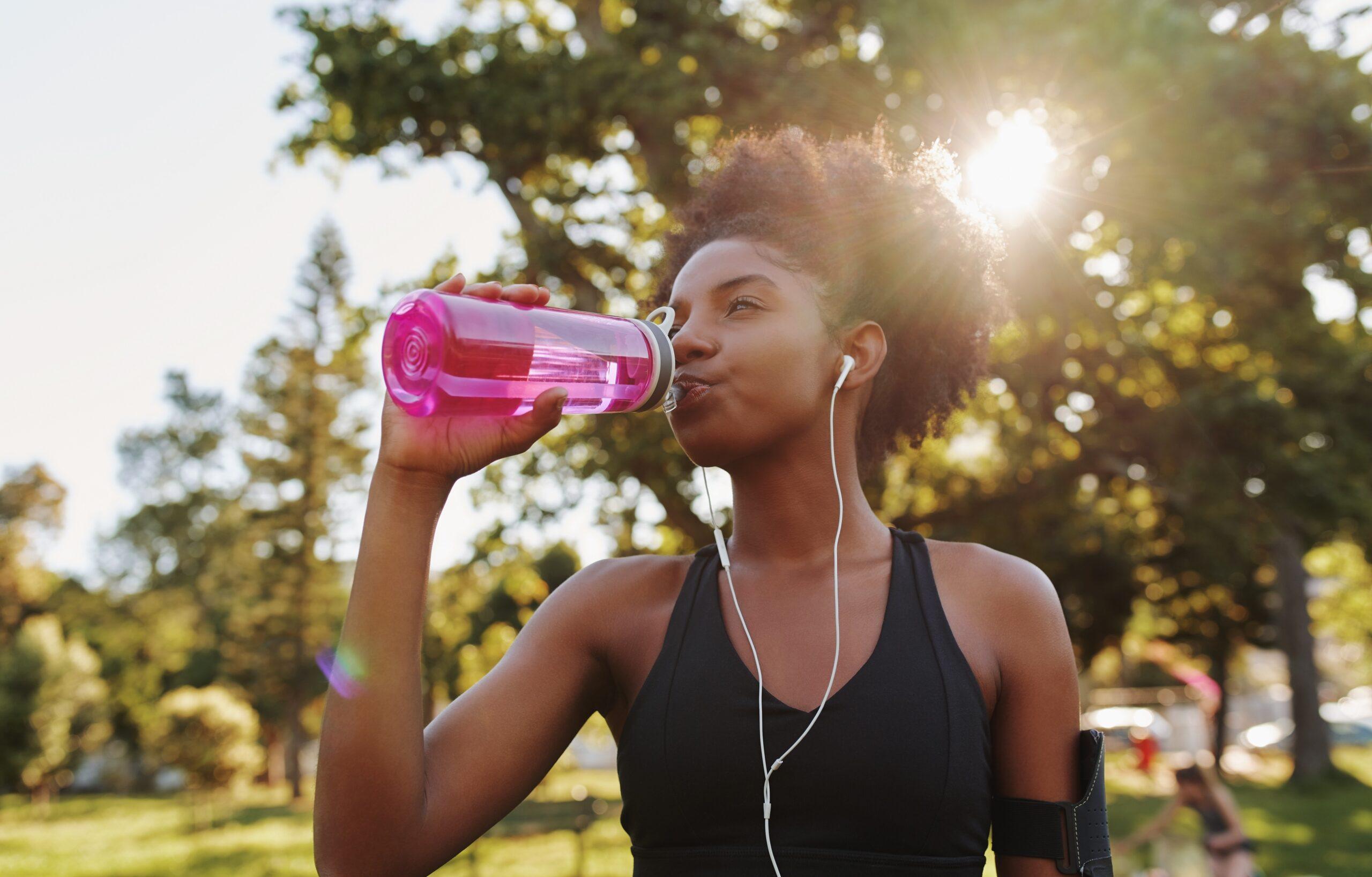 A person drinks water after exercising