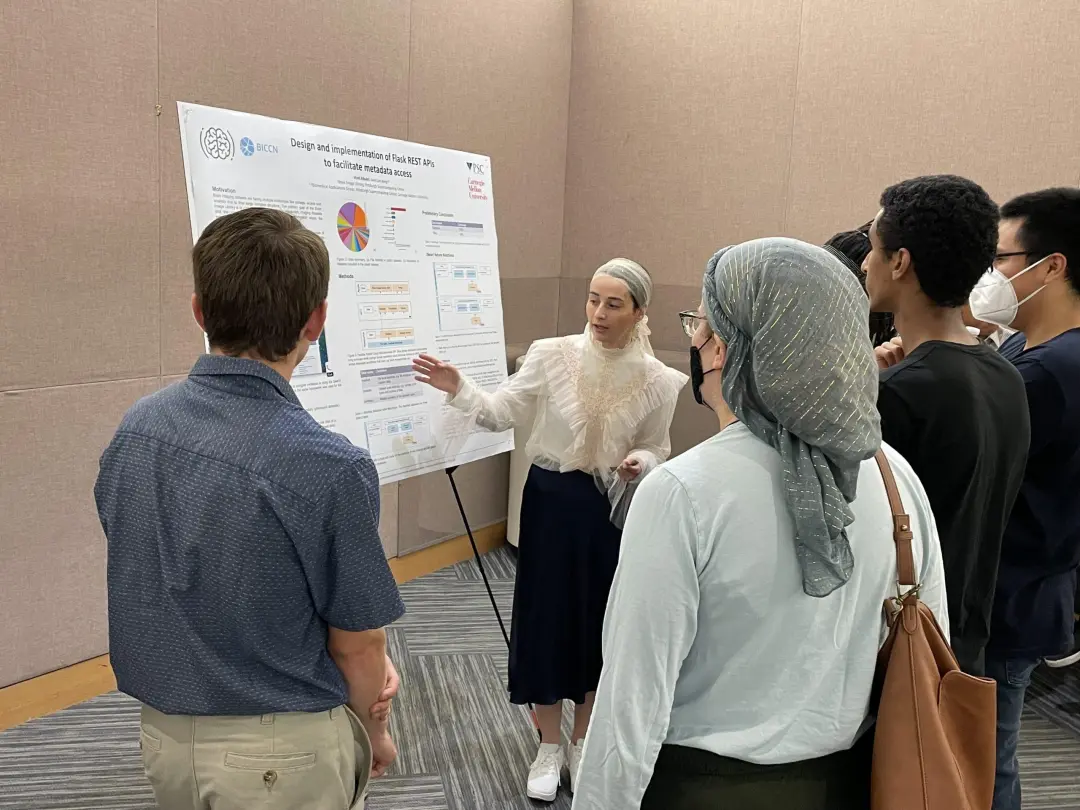 A person is presenting a research poster to a group of people.