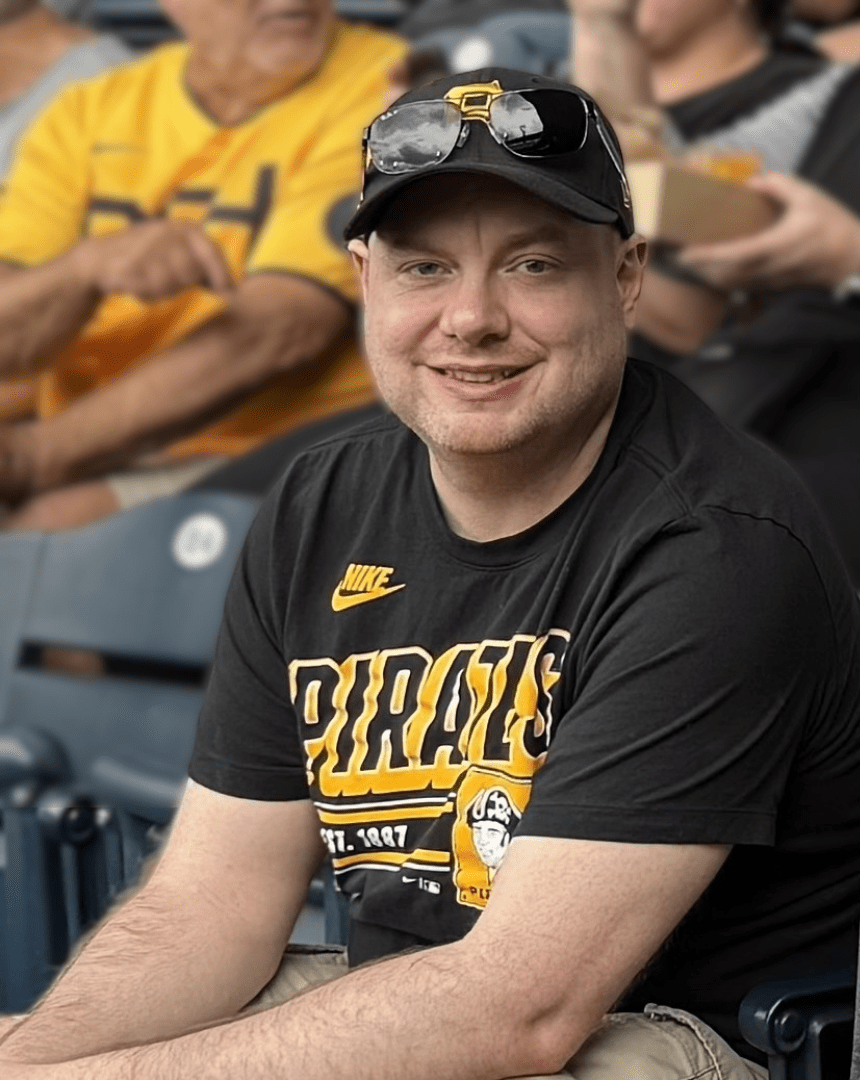 A man wears a Pittsburgh Pirates t-shirt and hat in a stadium