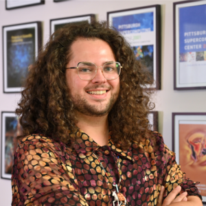 A person with curly brown hair and glasses